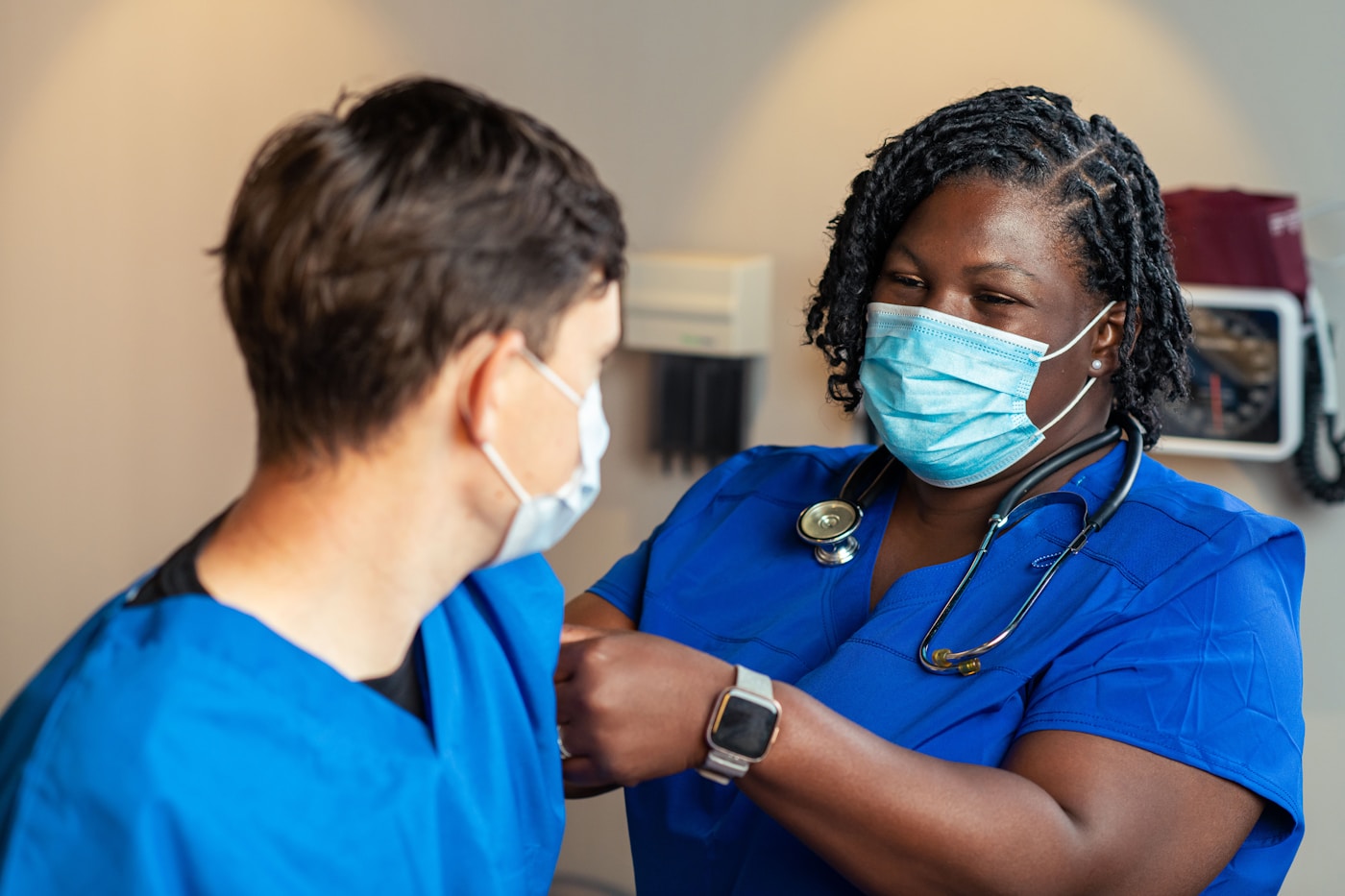 Two nurses in scrubs working together in a clinic