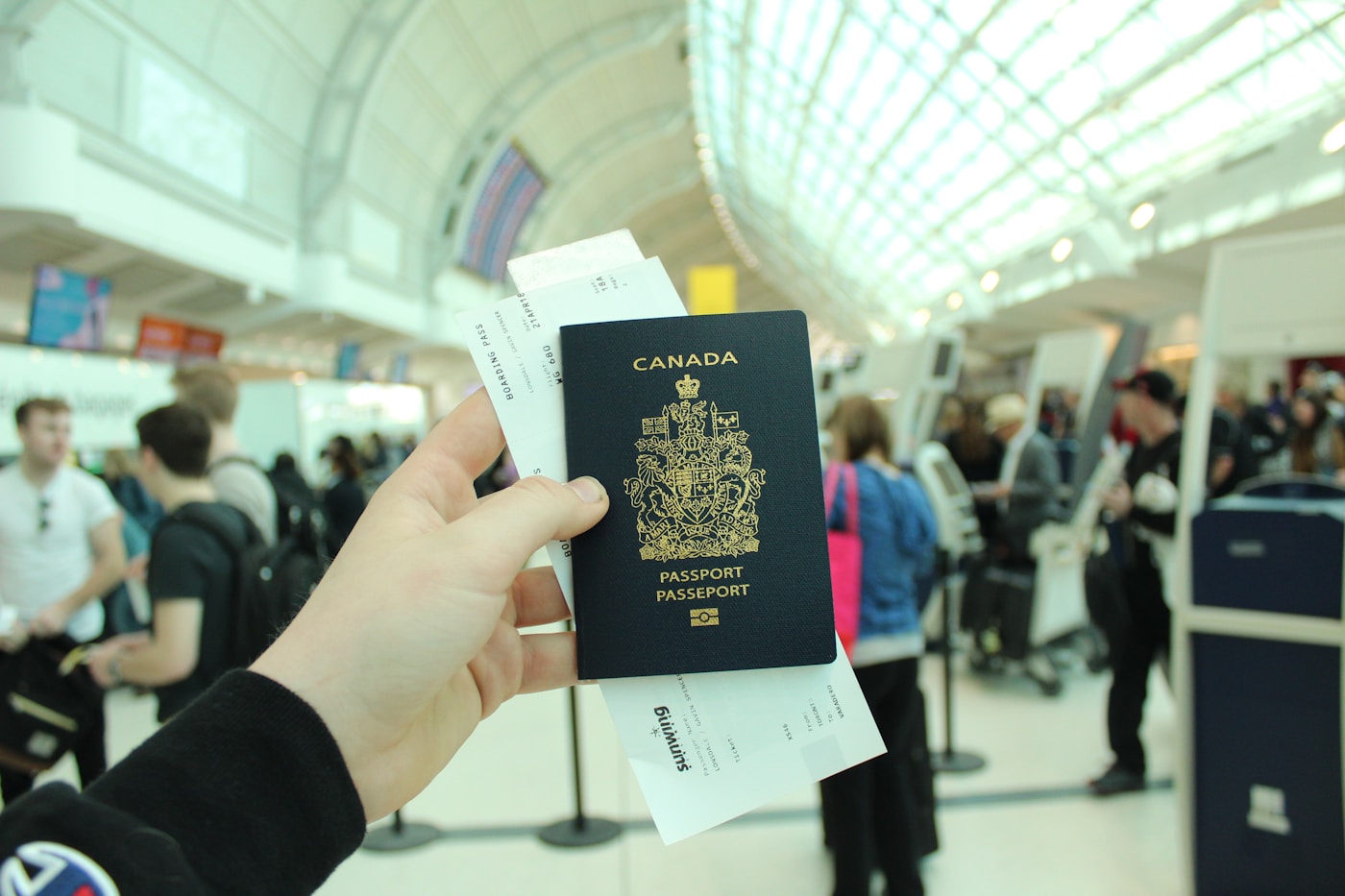 A Canada passport and boarding pass held at the airport