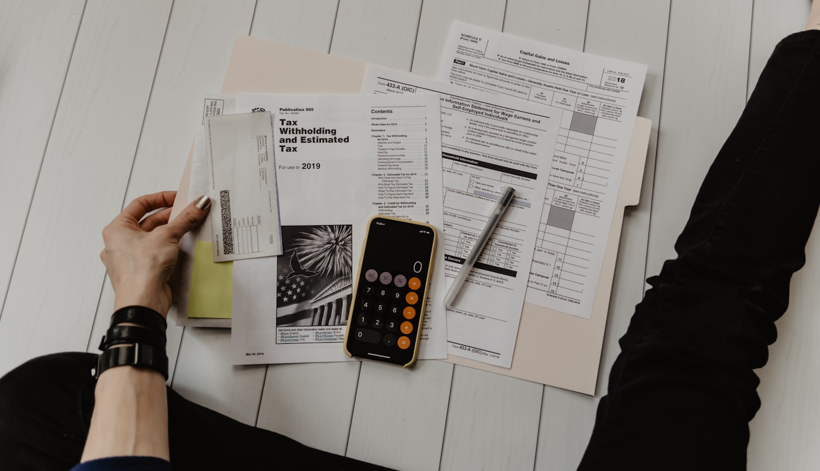 A student mapping out study costs with a calculator and financial paperwork